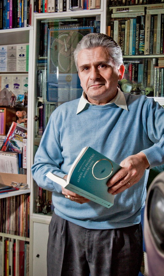 Roberto Pinotti in his archive, holding one of his books
